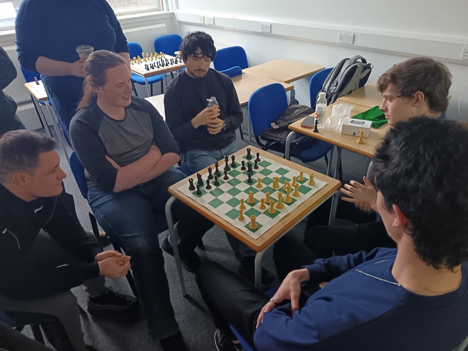 Chess Club members spectating a tense game of hand and brain chess